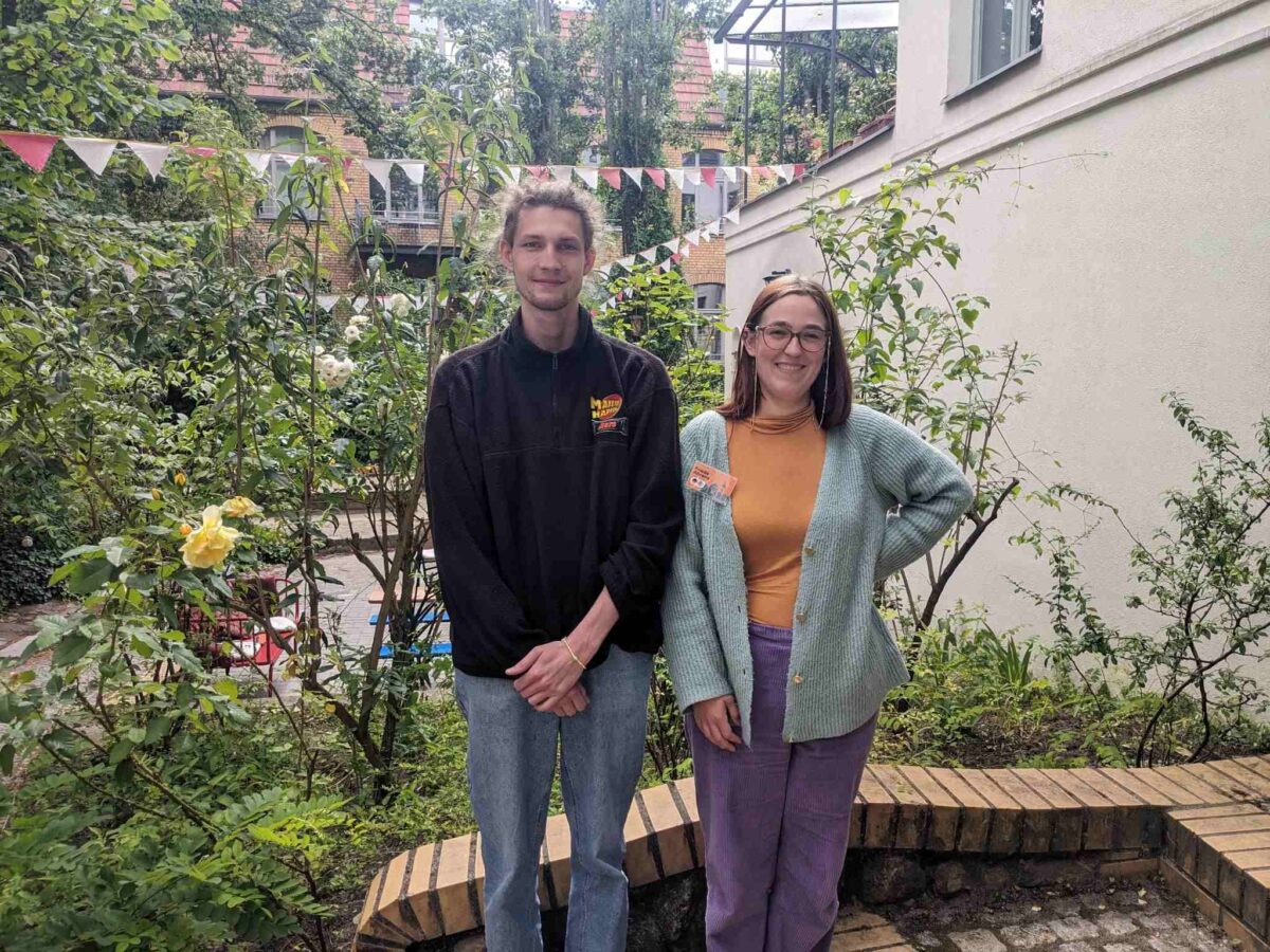 Jan-Niklas Müller und Frieda Ahrens stehen im Garten des Stadtteilzentrums Prenzlauer Berg